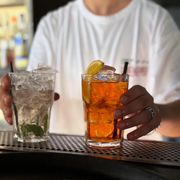 Il barman serve un mojito e uno spritz