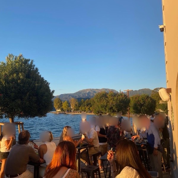 Il dehor pieno di gente al tramonto, con il lago sullo sfondo